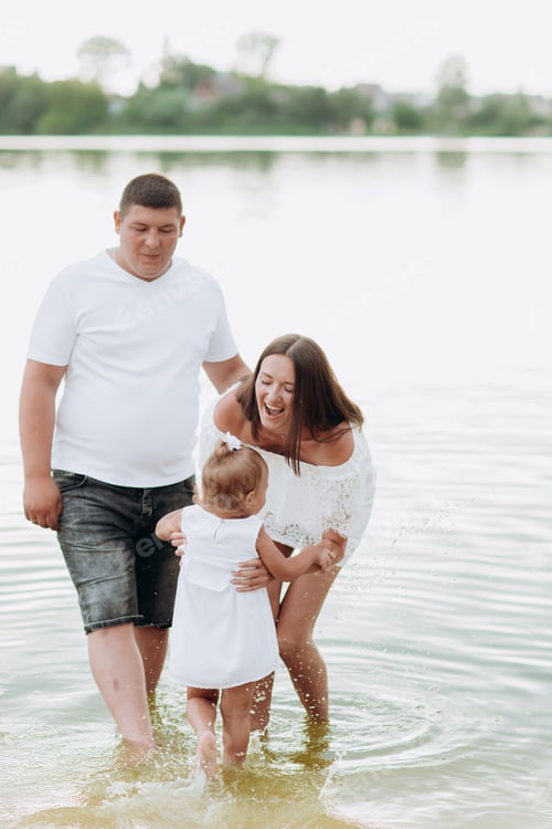 Preview: beautiful and happy young family, mom dad and daughter playing near the lake. summer holiday, M