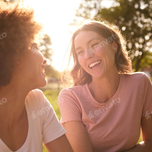 Preview: Two Female Friends Or Same Sex Couple Leaning On Fence On Walk In Countryside Together