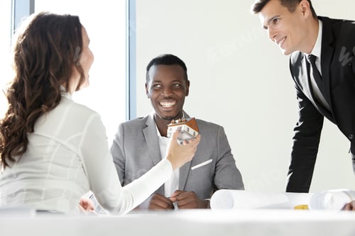 Preview: Teamwork and cooperation. Cute female contractor showing her colleagues new real estate project, hol