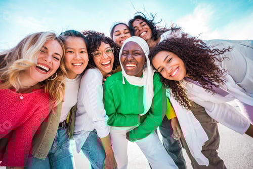 Preview: Multi ethnic group of young women hugging outside