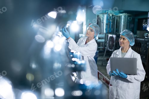 Preview: Portrait of a scientist in the drinking water factory using a ladder, looking at the water tanks