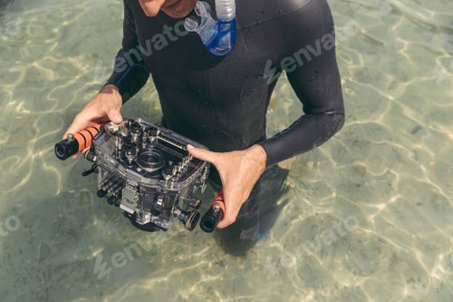 Preview: Man holding underwater DSLR camera case in a lake