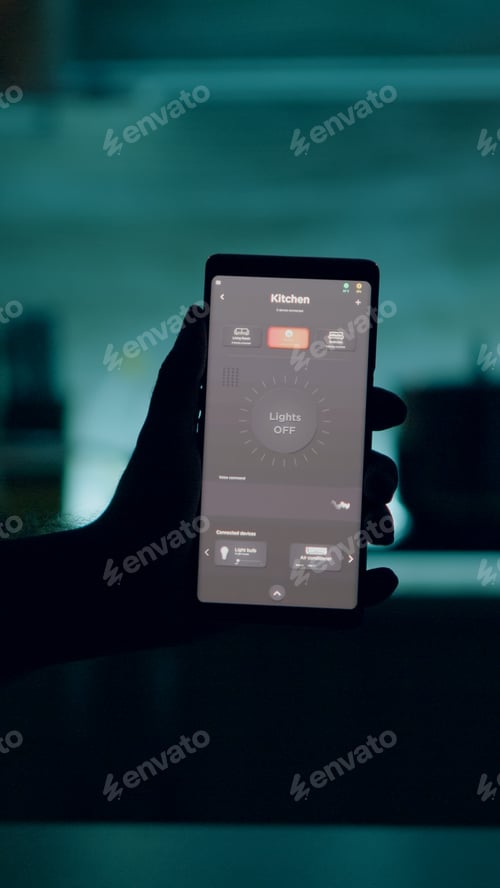 Preview: Man holding smartphone with lighting control application, turning on the lights