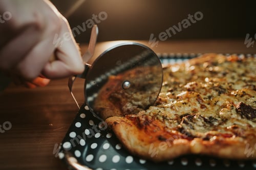 Preview: Closeup shot of cutting a freshly baked pizza