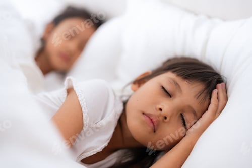 Preview: Two asian children sleeping peacefully in white bed holding hands