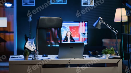 Preview: Home office desk in front of smart TV displaying news program broadcasting