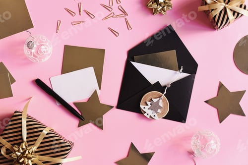 Preview: Black envelope, paper cards of gold and white color on pink background
