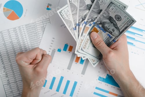 Preview: Close-up of hand holding money one hundred dollar bills on background of business documents