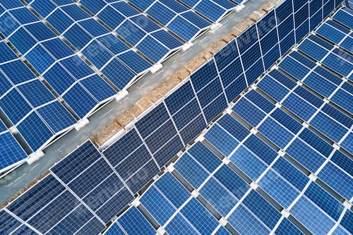 Preview: Aerial view of solar power plant with blue photovoltaic panels mounted on industrial building