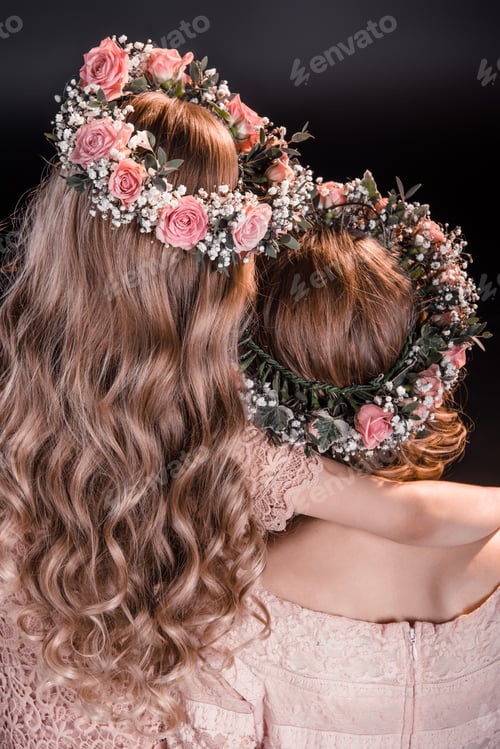 Preview: back view of mother and daughter in flowers wreathes isolated on black