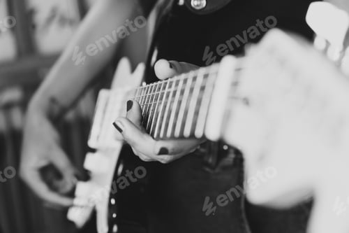 Preview: Close up of a pair of hands playing a guitar outdoors. Sunny day and practicing