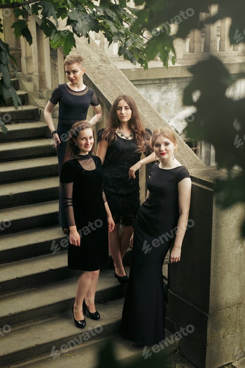 Preview: gorgeous luxury women in black dresses posing smiling on stairs under tree