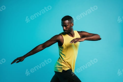 Preview: Sportsman doing stretching exercises in studio over blue background