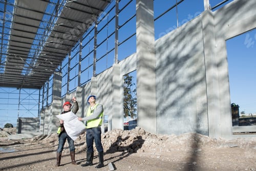 Preview: Builder and architect looking up at construction frame