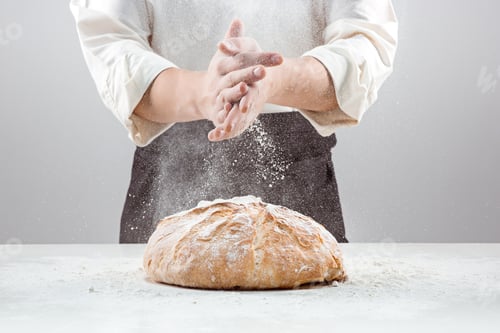 Preview: The male hands in flour and rustic organic loaf of bread
