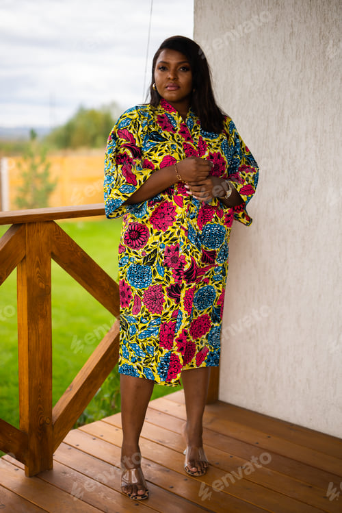 Preview: African american woman relaxing and enjoying sun while standing at terrace or balcony at sunlight at