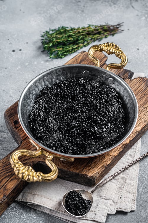 Preview: Luxury skillet with Black caviar on wooden board. Gray background. Top view