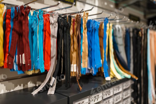 Preview: Colorful zippers on shelf in textile store, nobody