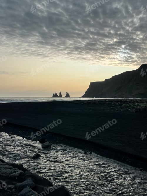 Preview: Silhouettes of rocks on the black sand beach in Vik Iceland during sunset