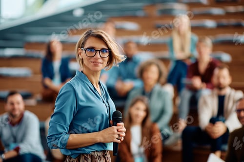 Preview: Female business seminar coach at convention center looking at camera.