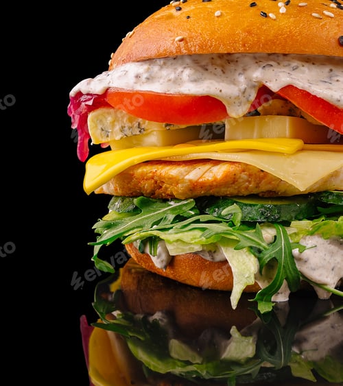 Preview: Delicious burger with fresh vegetables and creamy sauce on a dark background