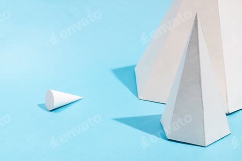 Preview: paper pyramids close up and lying cone top on blue