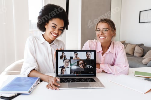 Visualização: Garotas multiculturais sorrindo enquanto fazem teleconferência no laptop