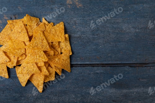 Preview: Directly above shot of crunchy nacho chips on wooden table with empty space