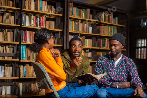 Preview: Young girl in and two men sitting in a library with a book in man's hands