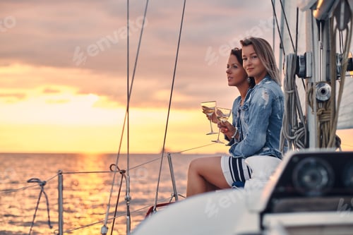Preview: Female friends relaxing on the yacht during sunset on the high seas.