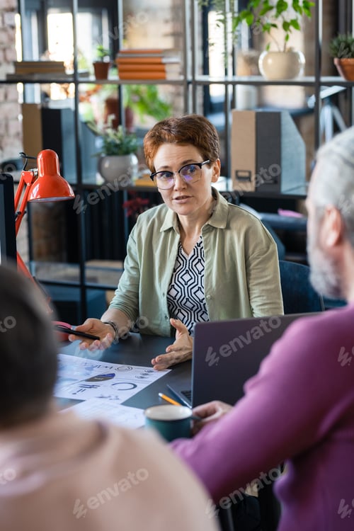 Preview: Businesswoman sitting at meeting with colleagues