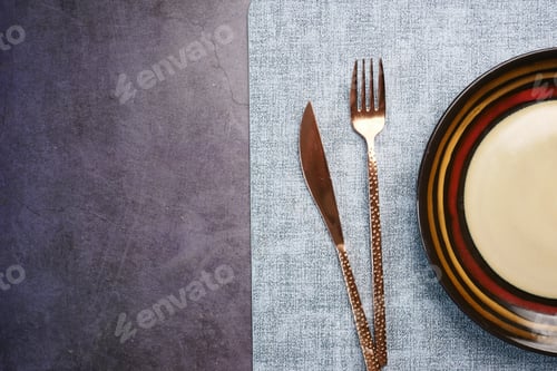 Preview: cutlery and empty plate on a black background with copy space