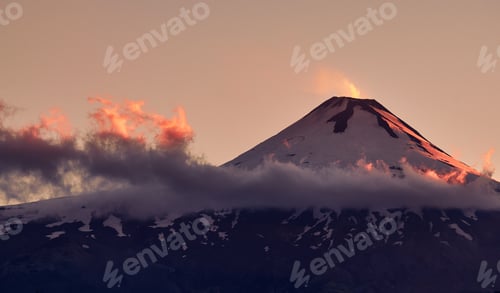 Preview: Mesmerizing view of the Villarrica volcanic mountain gleaming under the pink sky during sunset