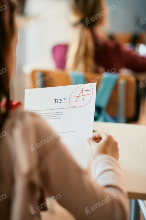Preview: Cloe-up of schoolgirl getting A grade on exam at elementary school.