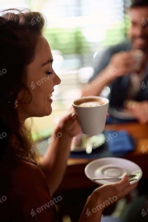 Preview: Happy woman enjoying in cup of coffee on a date.