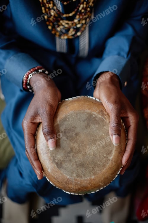 Preview: Black Adult Man Holding Traditional Drum Celebrating Kwanzaa Indoors