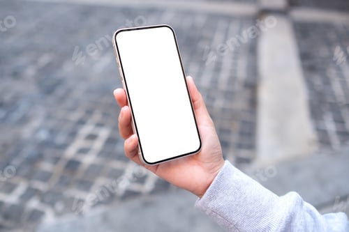 Preview: Mockup image of a woman holding and using mobile phone in the outdoors