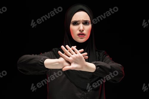 Preview: Portrait of beautiful desperate scared frightened young muslim woman wearing black hijab showing