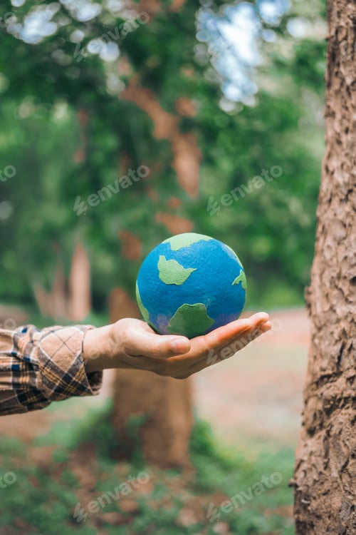 Preview: An Asian woman holds a globe in green forest,symbolizing importance preserving nature.emphasizes