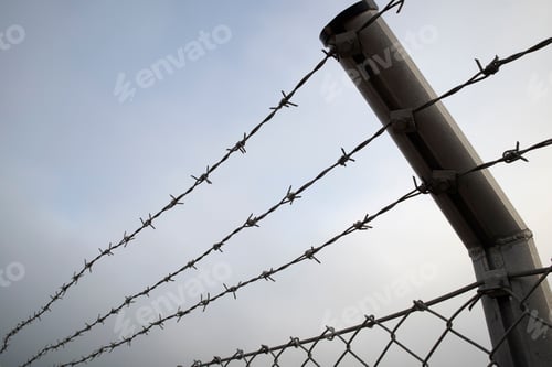 Preview: barbed wire lines against cloudy sky