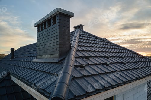 Preview: Snow guard for safety in winter on house roof top covered with ceramic shingles. Tiled covering of