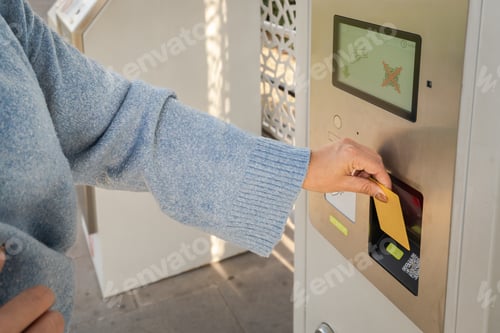 Preview: Close up of Woman's hand inserting card into a payment machine to purchase a ticket
