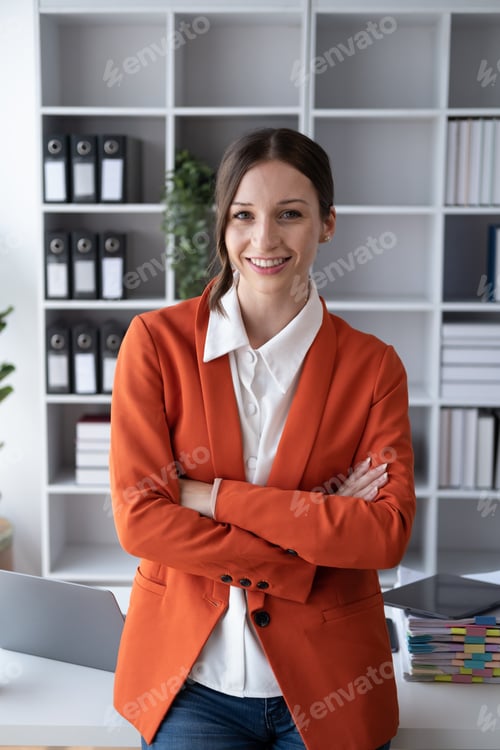 Preview: Confident young businesswoman keeping arms crossed and looking at camera.