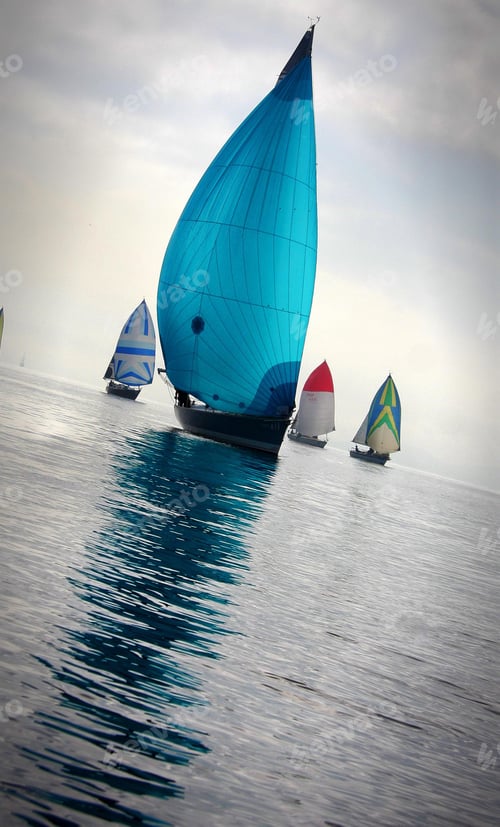 Preview: Vertical shot of colorful sail ships on the calm water