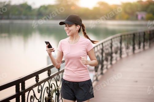 Preview: Young Woman Jogging and Using Mobile Phone