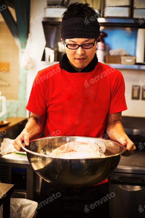 Preview: The ramen noodle shop. A chef preparing a huge metal bowl of broth with meat ingredients.