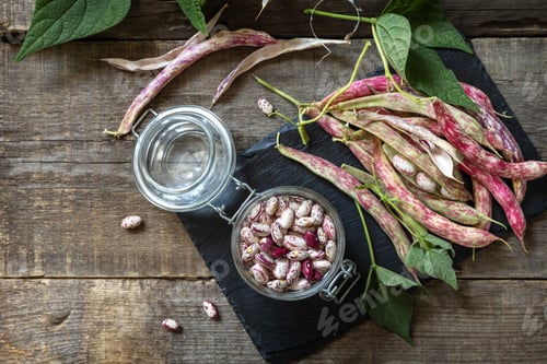 Preview: Beans of bean, brown bean (of dried beans) in a glass jar on a rustic table.