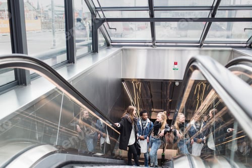 Preview: Friends sharing a laugh on an escalator in a modern urban setting