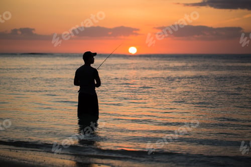 Preview: A man fishing in the Indian ocean with the beach at sunset