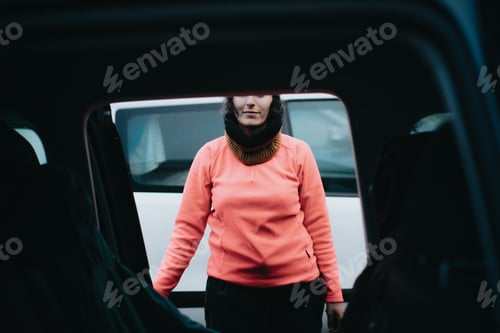 Preview: Woman in doorway wearing orange shirt and scarf